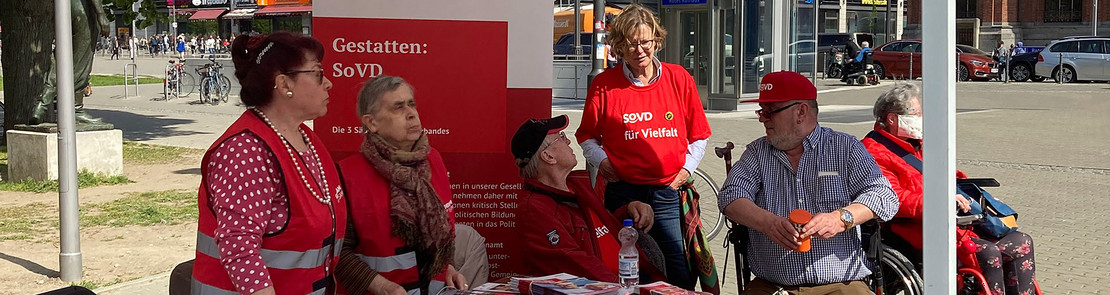 Menschen in SoVD-Kleidung an einem Infostand