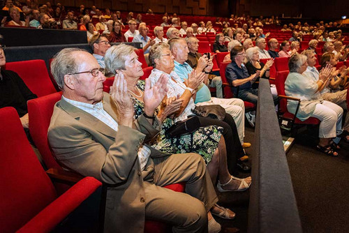 Zuschauer klatschen in einem Saal. 