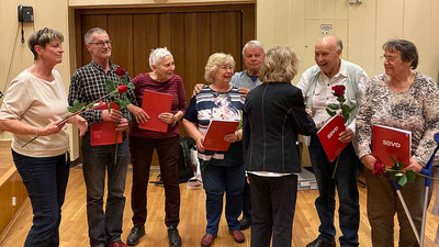 Gruppenbild von Menschen mit Blumen und Urkunden