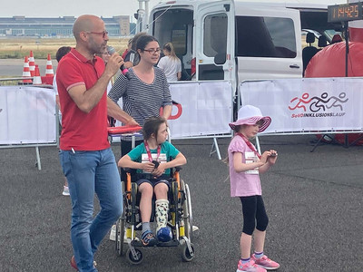 Zwei Erwachsene und zwei Kinder (eins im Rollstuhl) auf dem Tempelhof Feld